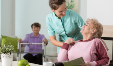 Interior residencia para mayores: una enfermera que habla con una señora mayor